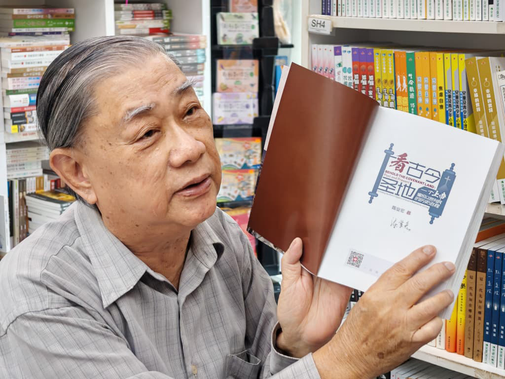 陈业宏教授手持新书《看古今圣地》，在文桥书房受访
